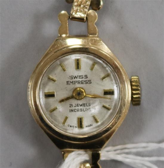 A ladys 9ct gold Swiss Empire manual wind wrist watch on a 9ct gold bracelet.